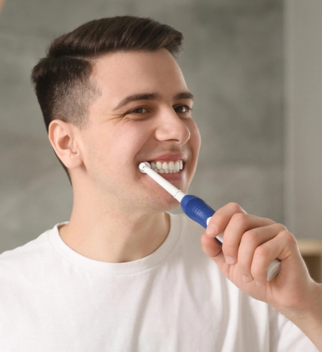 Young man practicing dental hygiene by brushing teeth